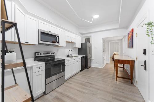 a kitchen with white cabinets and a stove top oven at 1734 Comfort Stay, 2 Bedrooms, 2 Bath with Kitchen & Wi-Fi in Washington, D.C.