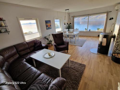 a living room with a leather couch and a table at Skogstad Ferie og fritid in Tromsø