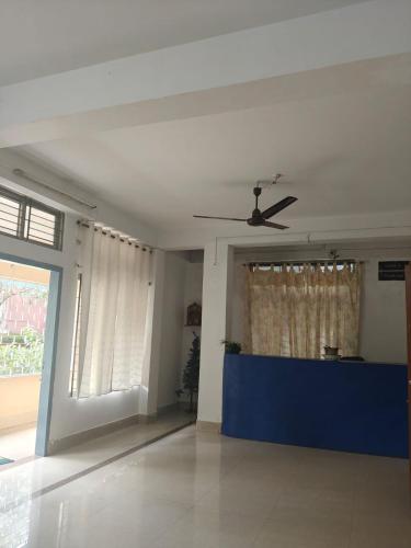 a living room with a ceiling fan and a blue table at Shimray's Minimalist Hostel in Guwahati