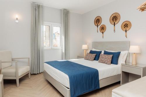 a bedroom with a large bed and a chair at AZUL in Zambujeira do Mar