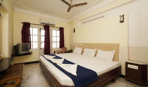 a bedroom with a large bed and a television at Hotel Sun Rock in Kanyakumari