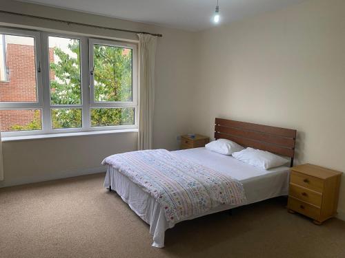 a bedroom with a bed and two windows at Langham Lake House in Simpson