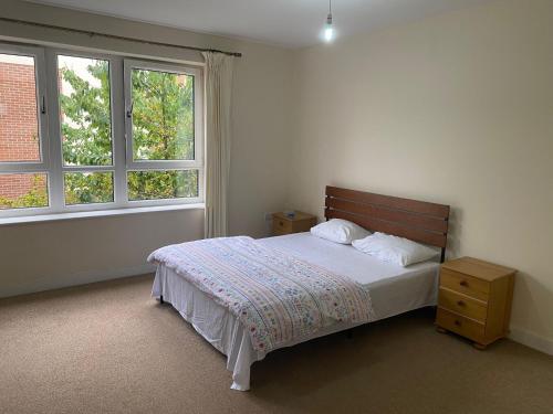 a bedroom with a bed and two windows at Langham Lake House in Simpson