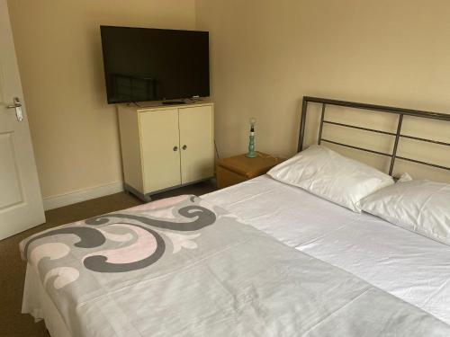 a bedroom with a bed and a flat screen tv at Langham Lake House in Simpson