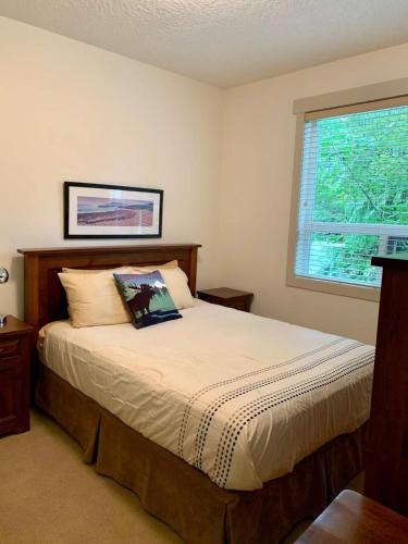 a bedroom with a bed with a pillow and a window at Sooke Harbour Hideaway - Luxurious Vacation Rental in Sooke