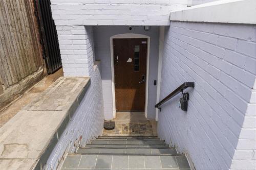 a hallway with stairs leading to a brown door at The 1731 Residence Unit 1 in Washington, D.C.