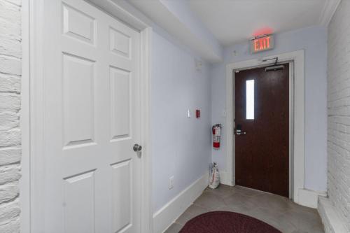 a hallway with a door with an exit sign on it at The 1731 Residence Unit 1 in Washington, D.C.