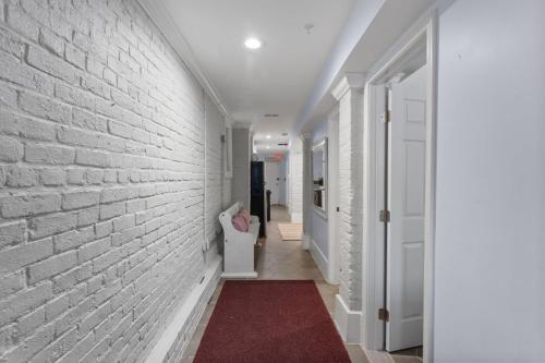 a hallway with a white brick wall and a red rug at The 1731 Residence Unit 1 in Washington, D.C.