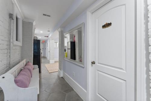 a hallway with a white door and a hallway with pink pillows at The 1731 Residence Unit 1 in Washington, D.C.