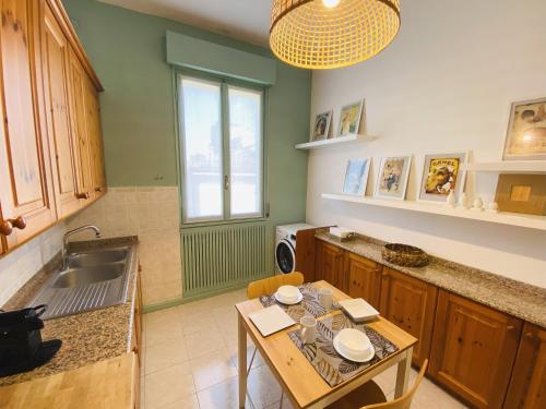 een keuken met een tafel en een wastafel bij Malmusi Apartment in Modena