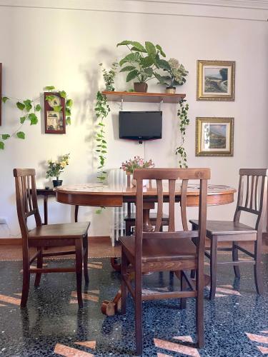 una sala da pranzo con tavolo, sedie e TV di Porto Di Colombo - Affittacamere vicino spiaggia e città a Genova
