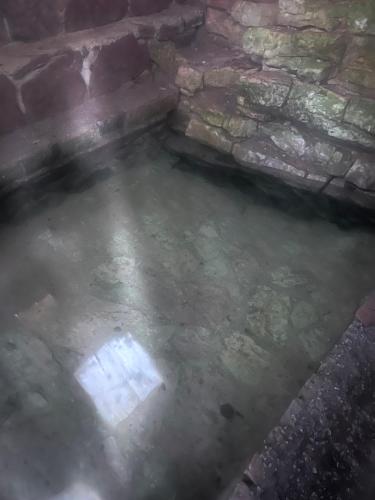 a pool of water next to a stone wall at Ferienhaus LAGUM in Rudo