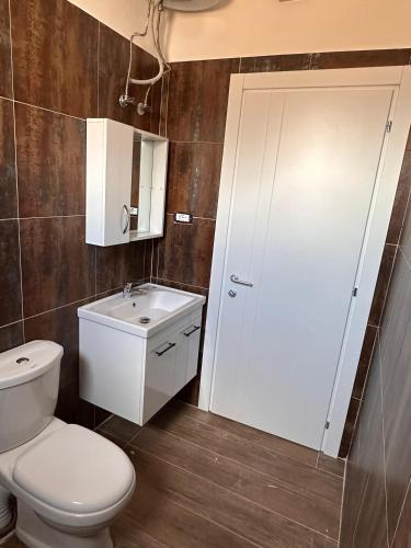 a bathroom with a toilet and a sink at Villa 2211 Berat in Uznovë