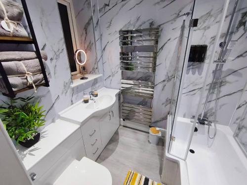 a bathroom with a tub and a sink and a shower at City Centre - Links Apartments - Close to Beach in Aberdeen