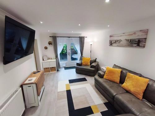 a living room with a couch and a tv at City Centre - Links Apartments - Close to Beach in Aberdeen