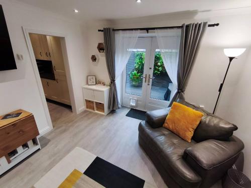 a living room with a leather couch and a window at City Centre - Links Apartments - Close to Beach in Aberdeen