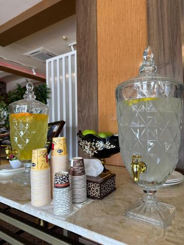 a table with a glass vase and stacks of plates at Al Jawahiri Hotel in Erbil