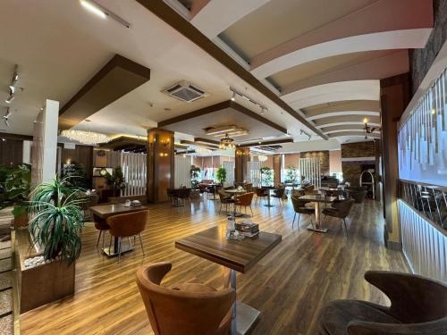 a lobby of a restaurant with tables and chairs at Al Jawahiri Hotel in Erbil