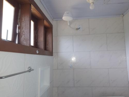 a bathroom with a shower with white tile at Casario in Florianópolis
