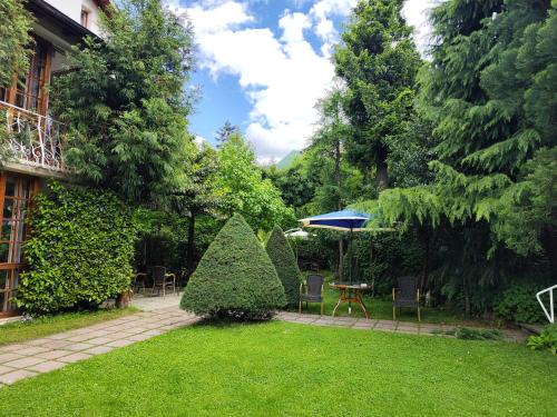a garden with two trees and a table and chairs at Park Hotel Amfora -Free Parking in Sofia