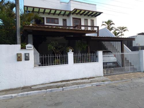 a white house with a fence in front of it at Casario in Florianópolis