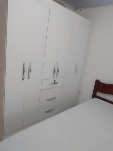 biała sypialnia z łóżkiem i białymi szafkami w obiekcie Casario w mieście Florianópolis