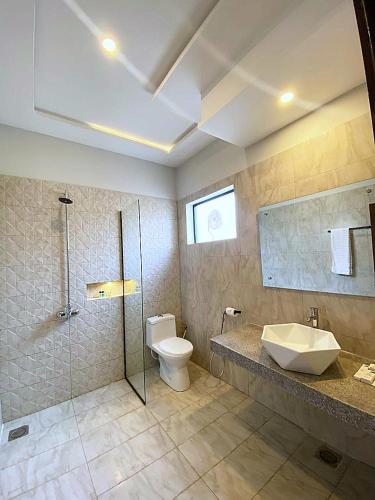 a bathroom with a toilet and a sink and a shower at Hotel Grand Suites in Multan