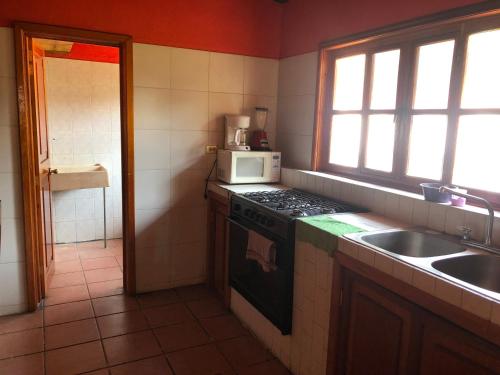 a kitchen with a stove and a sink and a microwave at villa de descanso y convivió familiar en Nepantla in Nepantla de Sor Juana Inés de la Cruz