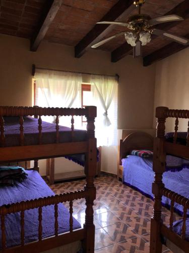 a bedroom with two beds and a ceiling fan at villa de descanso y convivió familiar en Nepantla in Nepantla de Sor Juana Inés de la Cruz