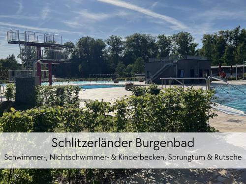 a swimming pool at a water park with the words schilker lender burgerbad at ALTE FÖRSTEREI - Elegantes Apartment in der historischen Hinterburg Schlitz - mit Aufzug, Parkplatz & Garten - nahe Fulda und Bad Hersfeld in Schlitz