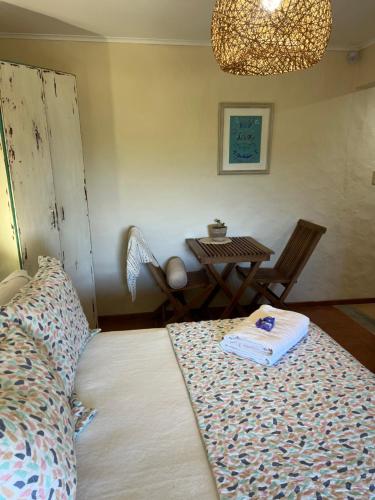 a bedroom with a bed and a table with a table at Posada de la Viuda in Punta Del Diablo