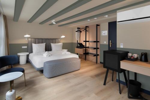 a bedroom with a white bed and a desk at Hotel Zeedijk City Centre in Amsterdam