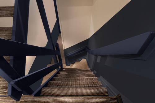 a set of stairs with black railings in a building at Hotel Zeedijk City Centre in Amsterdam