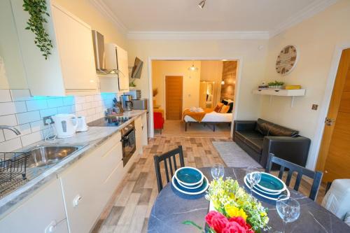 a kitchen and living room with a table and chairs at Studio with additional sofa bed - Eastbourne in Eastbourne