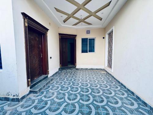 einen leeren Flur mit Fliesenboden und Türen in der Unterkunft Multan house in Multan