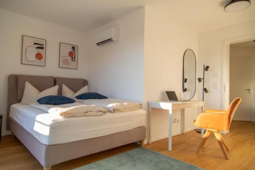 a bedroom with a bed and a desk and a mirror at Modernes Penthouse mit Bergpanorama & großer Terrasse, für bis zu 8 Personen in Waldkirchen