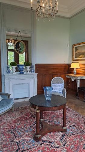 a living room with a table and a fireplace at Castle Of Saint Germain Des Rives in Saint-Germain-des-Rives