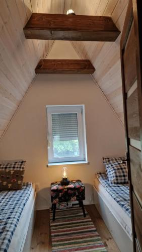 een kamer met 2 bedden en een tafel op zolder bij Velencei Odú in Velence
