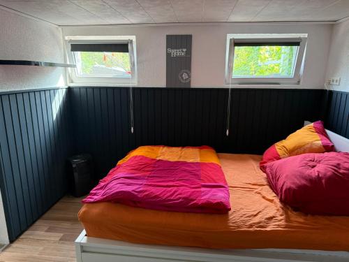 a large bed in a room with two windows at Apartment Heidchen in Knüllwald