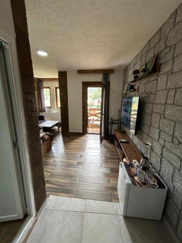a living room with a stone wall and a floor at Villa ANA-Mavrovo in Mavrovo