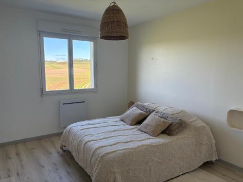 a bedroom with a large bed with a window at La petite maison in Buchey