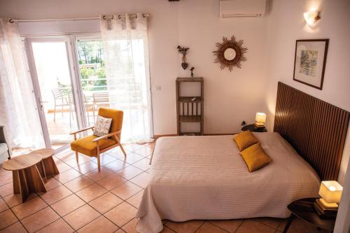 a bedroom with a bed and a table and a chair at Domaine de Pianiccia in Sari Solenzara