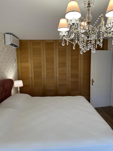 a bedroom with a large bed with a chandelier at Villa Myrto Nafpaktos in Nafpaktos