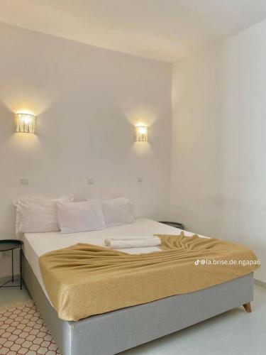 a bedroom with a bed with two lights on the wall at La Brise de Ngaparou in Ngaparou