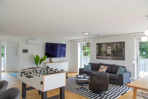 a living room with a foosball game in the center at Modernes Penthouse mit Bergpanorama & großer Terrasse, für bis zu 8 Personen in Waldkirchen