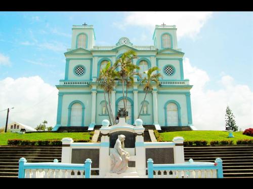 a blue church with a statue in front of it at Hostel des 3 sources in Sainte-Marie
