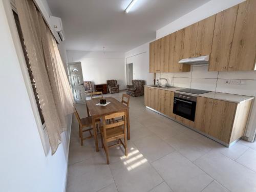 ペリヴォリアにあるCozy 2BR in Pervolia Near Beach Free Parking and many moreのキッチン(木製のキャビネット、テーブル付)