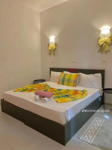 a bedroom with a large bed with towels on it at La Brise de Ngaparou in Ngaparou
