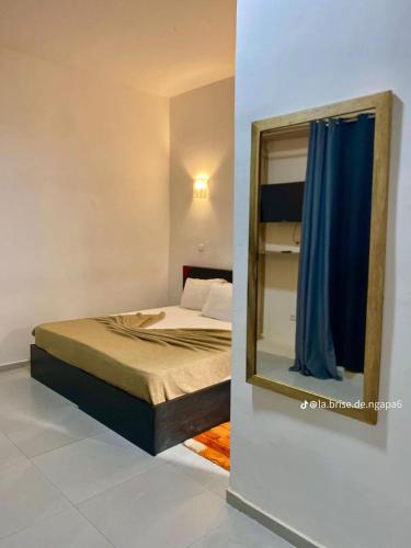 a bedroom with a bed and a mirror at La Brise de Ngaparou in Ngaparou