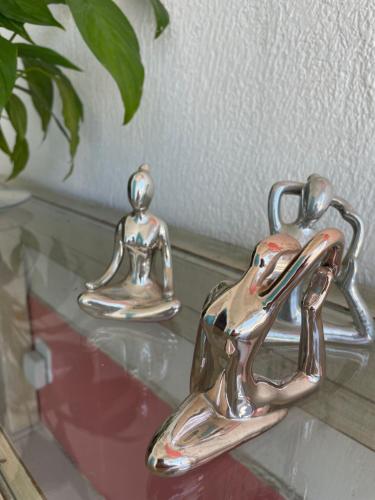 two metal birds sitting on top of a glass table at Beira Mar Hostal Buzios in Búzios